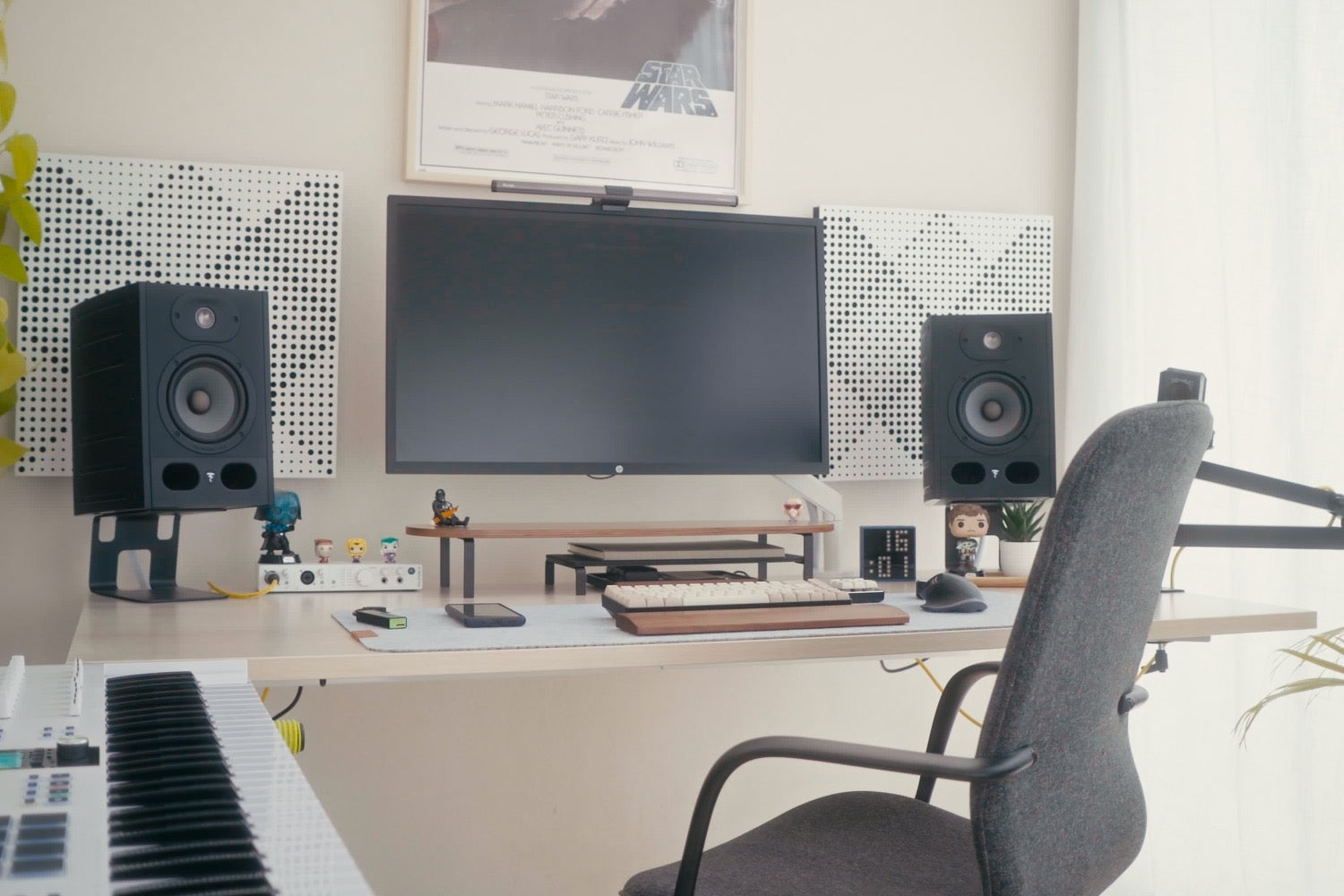 Bureau assis-debout avec un ordinateur installé dessus, accompagné d'enceinte et plusieurs accessoires de bureaux, créant un réel espace de travail